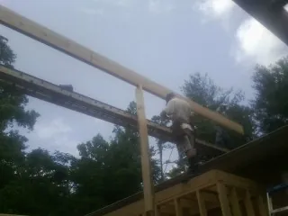 Carpenter setting a ridge beam over a new addition frame — Ice Dam Removal by Roofing Brothers in Veedersburg