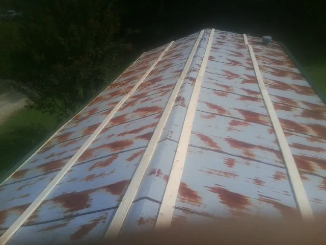 Rusted metal roof panels with new wood purlins before replacement — Storm Damage Roof Repair in Veedersburg by Roofing Brothers