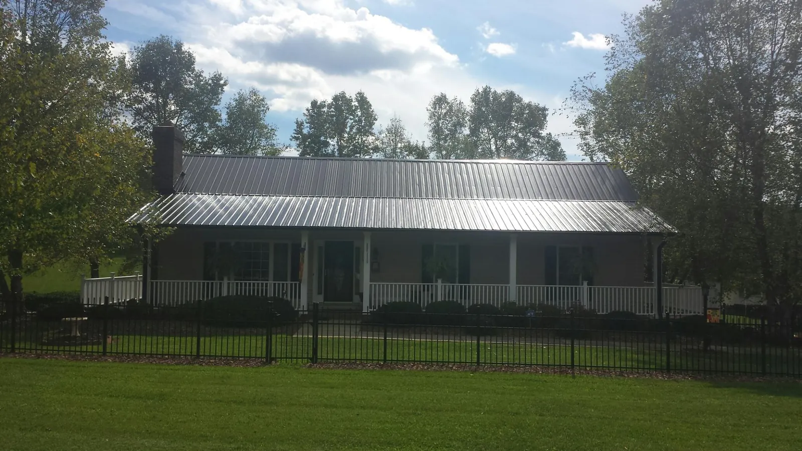Gray metal roof on a brick ranch with a full width front porch — Gutter Guard Installation work by our crew in Veedersburg