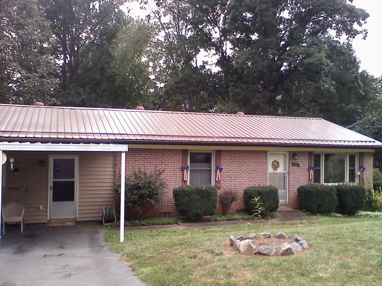 Bronze metal roof and carport on a brick ranch home — Roof Repair work by our crew in Veedersburg